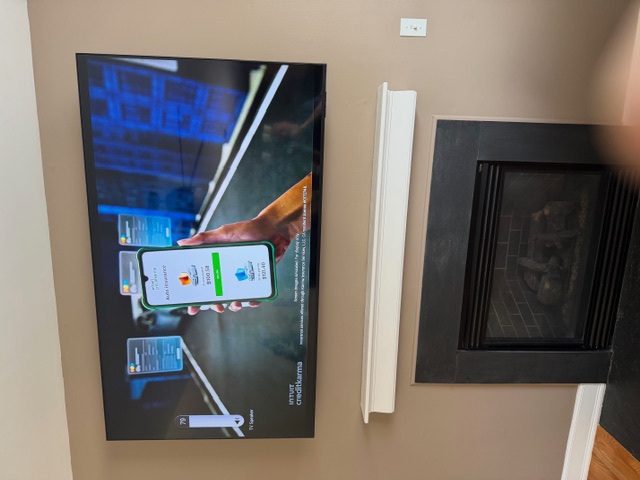 TV mounted above a fireplace, wires hidden