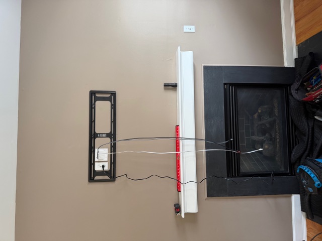 Before: bare wall mount and dangling wires above a fireplace