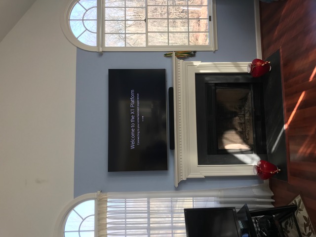 TV and soundbar above white fireplace with vaulted ceiling in NJ home