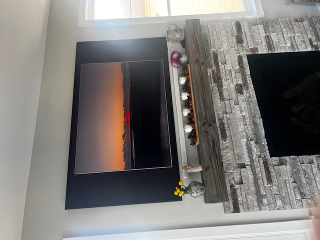 Samsung Frame TV displaying sunset art next to stone fireplace in NJ